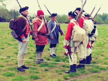 Colonial soldiers looking at each other on the battlefield.