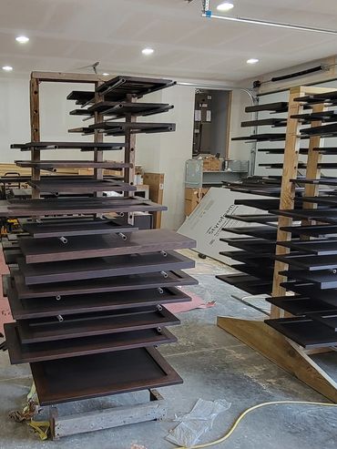 freshly lacquered doors drying on racks during a professional cabinet refinishing project