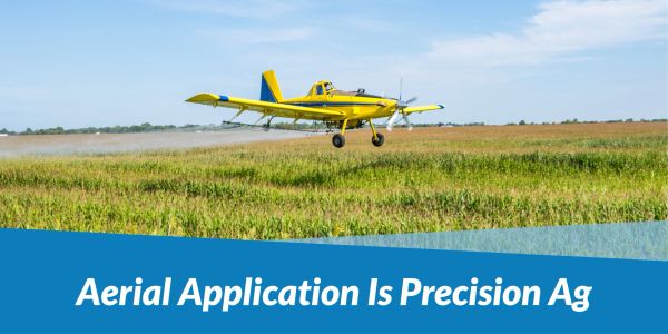 Yellow crop-dusting plane spraying fields with precision agriculture techniques.
