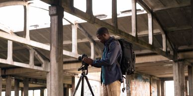 Photographer under a structure, highlighting design and ambiance, with real estate elements
