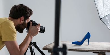 Product Photography: Photographer filming a high-heeled shoe, showing products for e-commerce or ads.