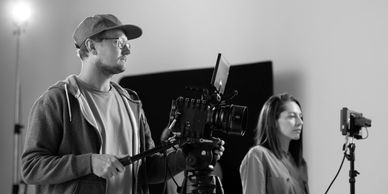 Event Photography: Photographer filming an event with a model, preserving event memories.