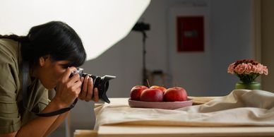 Photographer filming items on a table, highlighting skill in product showcases.