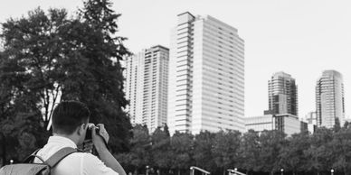 Photographer shooting a tall building, displaying work on industrial processes and facilities.