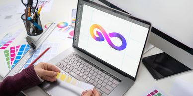 Creative professional animating colorful logo on laptop for brand identity.
