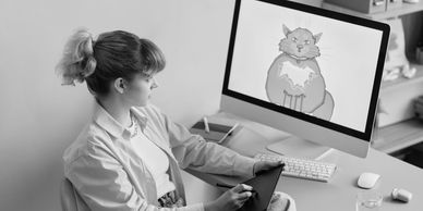 Animator creating expressive character animation on desktop, highlighting storytelling in 2D and 3D.