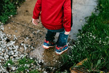 Stock image of child, jumping in puddle