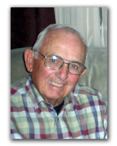 Smiling elderly man wearing glasses and a plaid shirt.