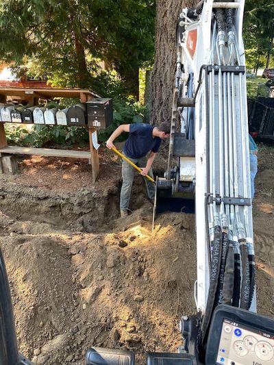 Owner, Trey Metzner, helping the excavator work around tree roots so as not to harm the tree.