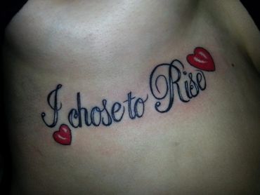 Black and grey script lettering with red hearts tattoo.