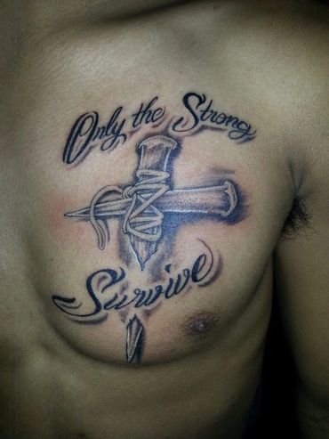 Lettering tattoo with a cross on a chest.