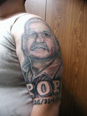 Memorial black and grey portrait tattoo of an older man with lettering.
