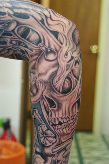 Black and grey skull on a sleeve tattoo.