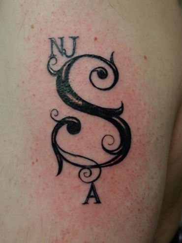 Lettering tattoo of large initial.