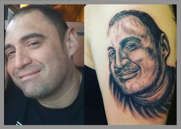 Black and grey portrait tattoo of a man on an arm.