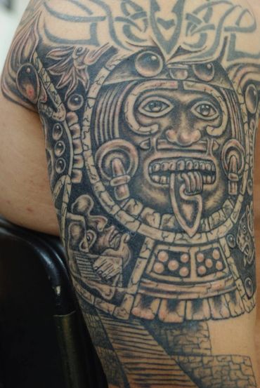 Black and grey Aztec arm tattoo.