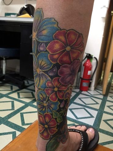 Color flower tattoos on a woman's lower leg.