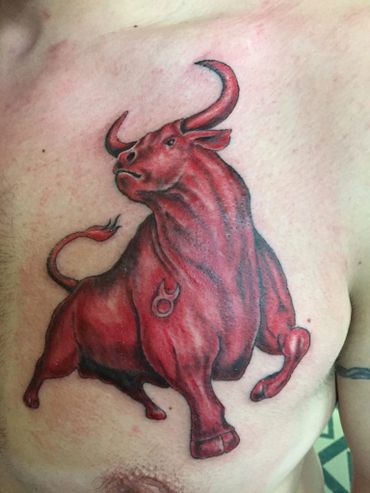 Red Taurus bull tattoo on a man's chest. 