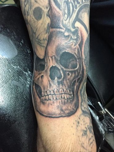 Black and grey skulls on a sleeve tattoo.