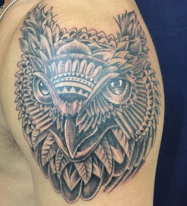 Tribal black & grey owl tattoo on a man's arm.