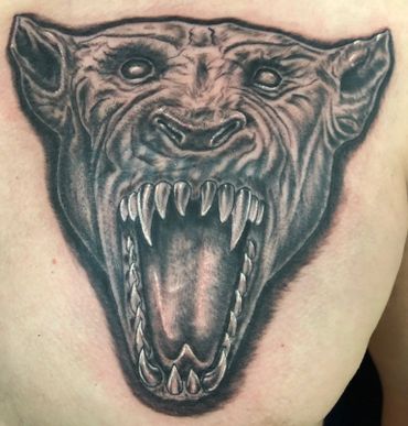 Black and grey demonic beast tattoo on a man's chest.