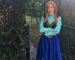 Person dressed as Anna from Frozen in a garden setting.