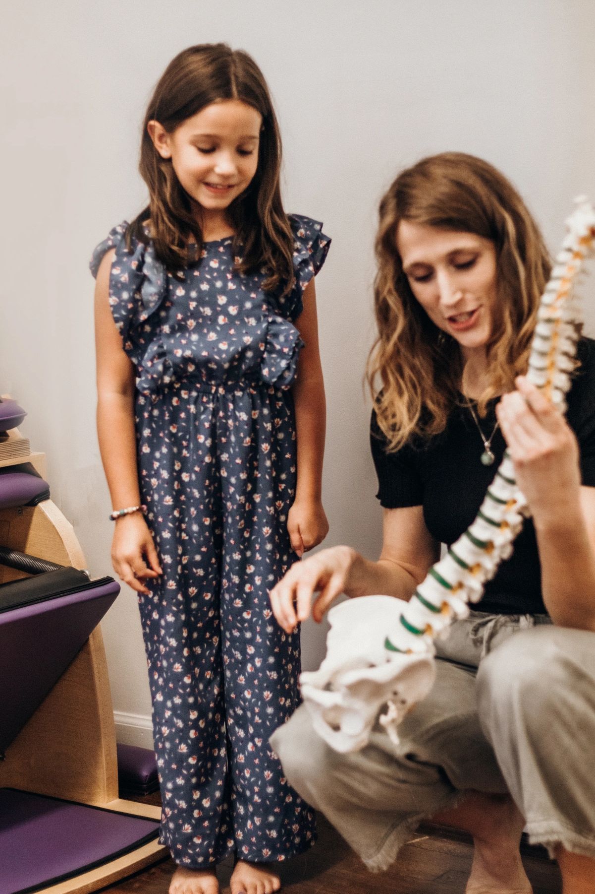 chiropractor with spine model talking to child