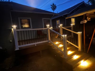 Illuminated porch stairs at night with warm lighting.