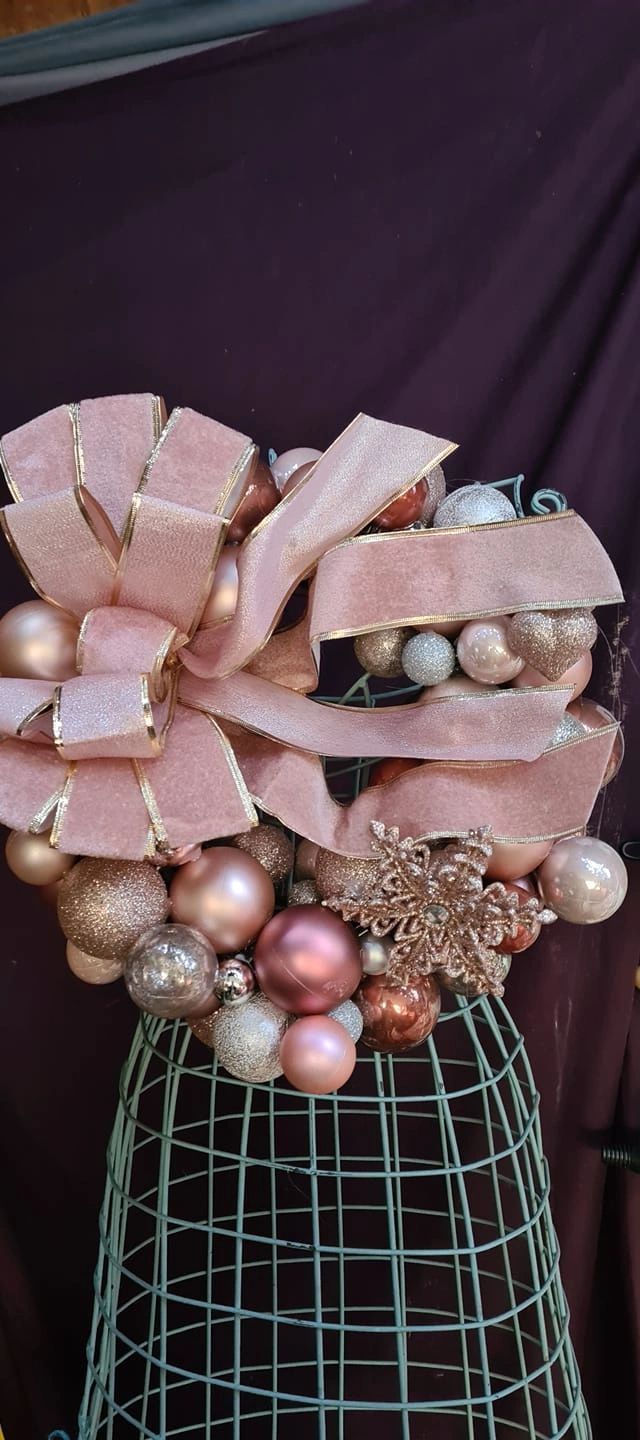 Sparkling baubal wreath in pinks and silver. Finished in a voluptuous gold edged ribbon with bow.