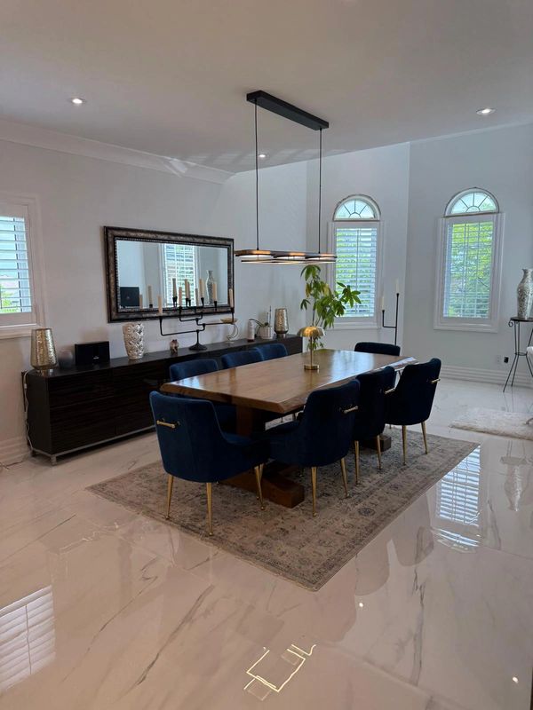 Modern dining room with blue chairs and wooden table.