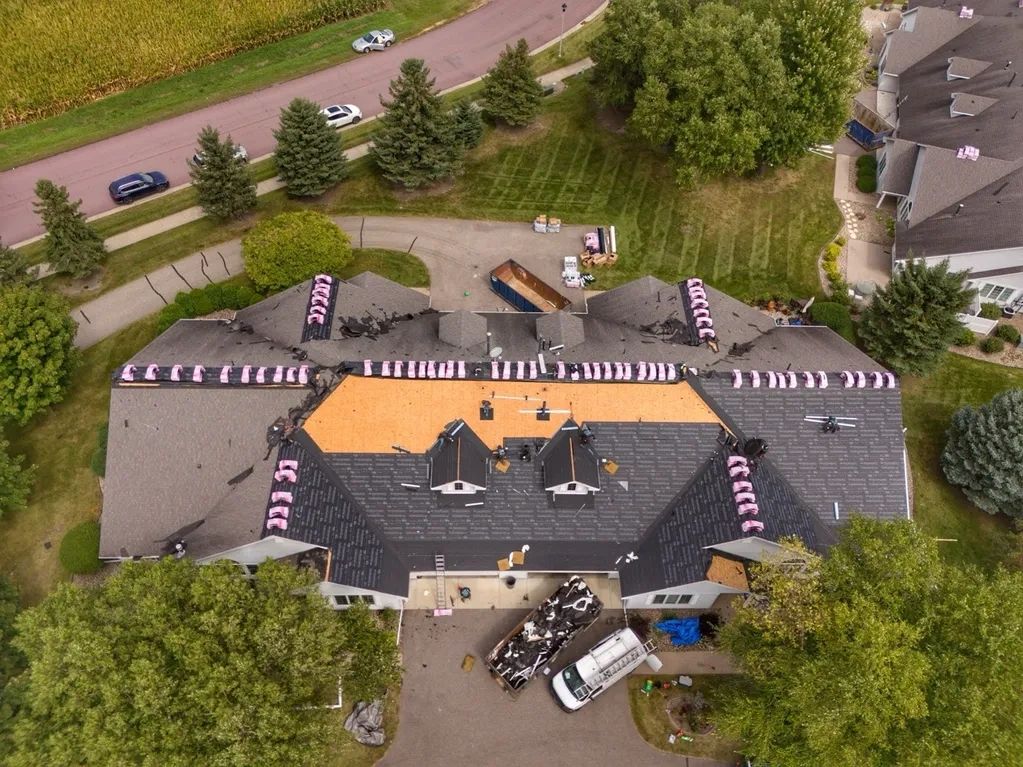 Aerial drone photo of a restoration crew replacing shingles on a townhome in Saint Peter, Minnesota