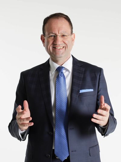 AuxBridge 创始人兼 CEO Michael Girel 的肖像,象征公司在全球技术解决方案领域的领导地位。