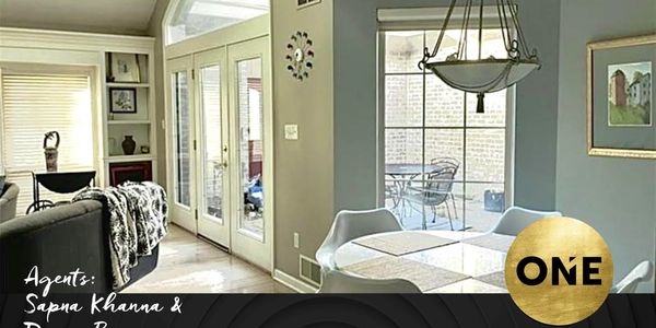 Modern dining area with glass table and large windows.