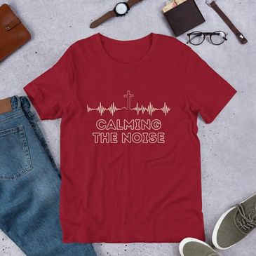 Red t-shirt with a heartbeat and cross design saying 'Calming the Noise'.