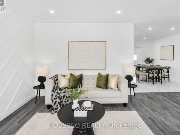 Modern living room with neutral tones and green accents.