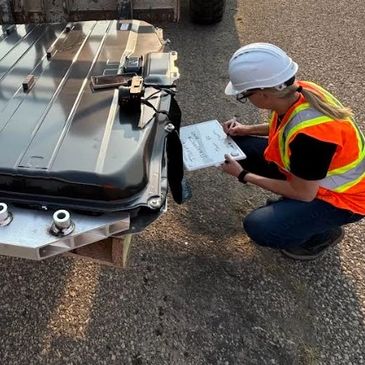 Worker inspecting equipment and taking notes.