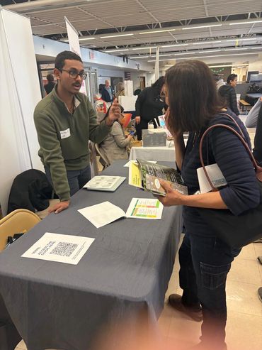Man explains information to woman at a booth.