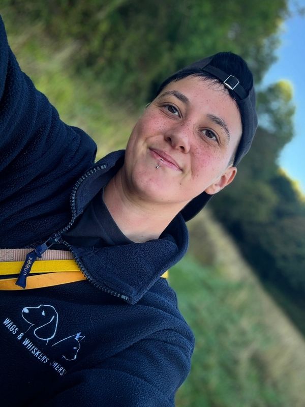 Young person smiling outdoors in casual wear.
