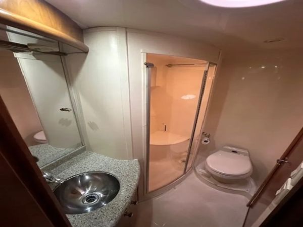 Compact and modern yacht bathroom with stainless steel sink and enclosed shower.