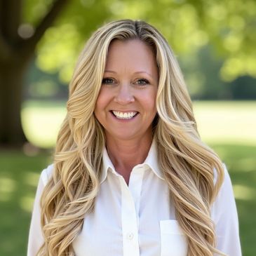 Smiling woman with long blonde hair outdoors in a white shirt.