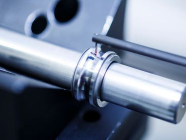 Precision measurement of a metal cylindrical part with a probe.
