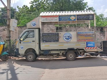 A welfare society truck with informative boards parked on a street.