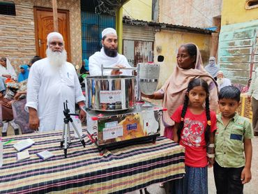 Community members showcasing a water purifier machine in a neighborhood.