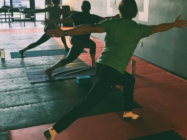 Three people practicing yoga in a studio.