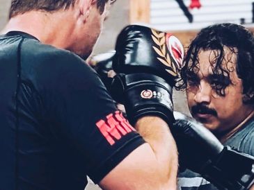 Two men training in boxing with gloves.