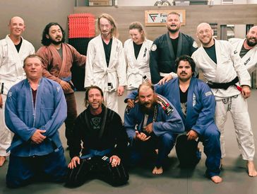 Group of people in martial arts uniforms posing for a photo.
