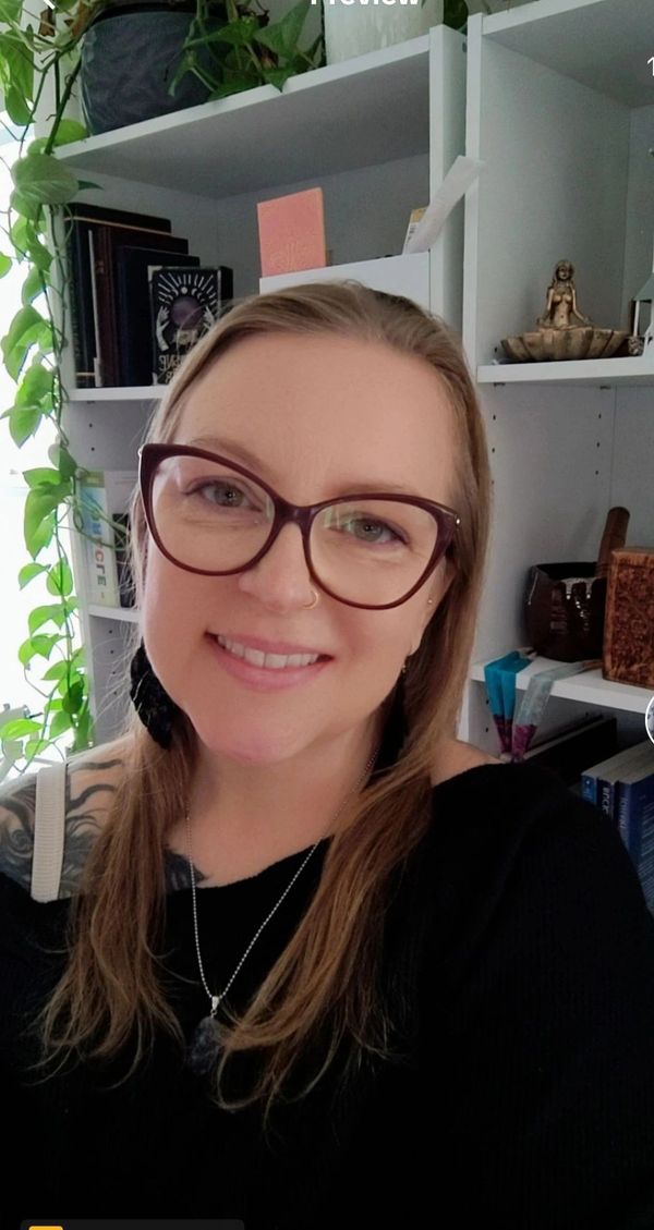 Smiling woman with glasses and long hair.