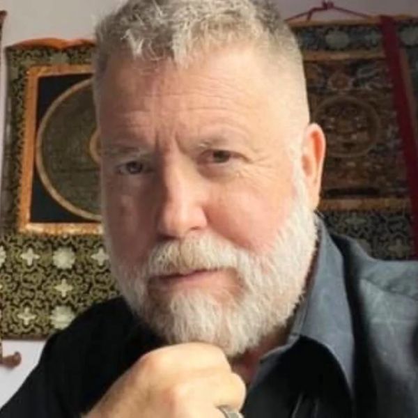 Mature man with white beard looking thoughtfully.