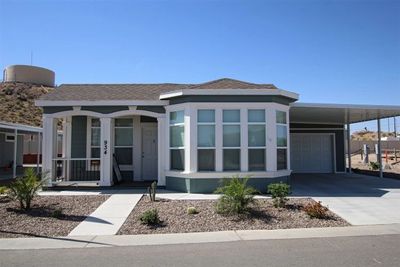 Single-story house with large front windows and a carport.