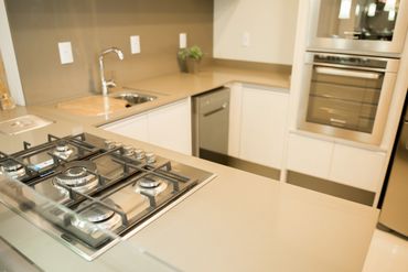 Bancada de cozinha em quartzo Unsui, fogão cooktop, torneira cromada.